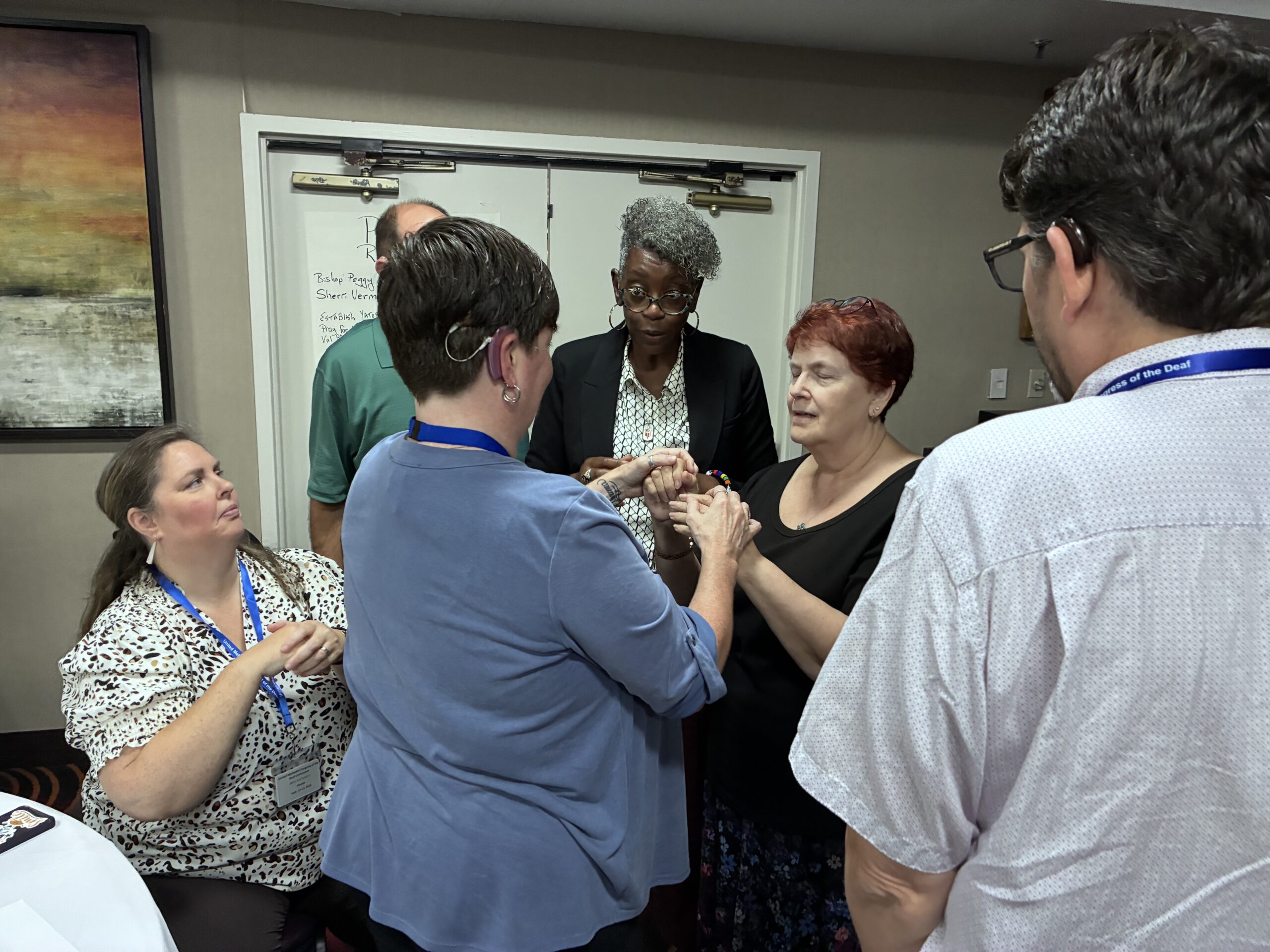 Bishop Williamston speaking with a DeafBlind woman.